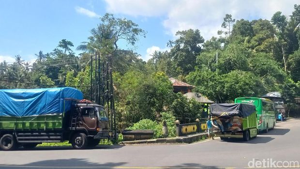 Sejumlah pengemudi truk beristirahat untuk mendinginkan mesin kendaraan di wilayah Buleleng, Jalan Singaraja-Denpasar, Selasa (8/7/2025). (Made Wijaya Kusuma)