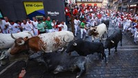Adrenalin memuncak saat banteng Cebada Gago dilepaskan di jalan sempit Pamplona dalam tradisi tahunan yang penuh risiko ini.  REUTERS/Albert Gea