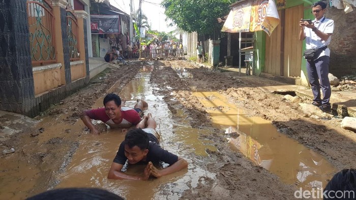 Warga Cirebon mandi lumpur di jalan rusak.