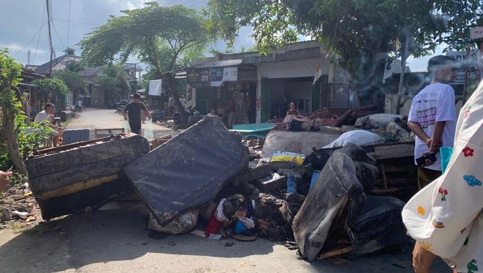 Warga Lingkungan Karang Tumbuk, Kelurahan Mayura, Kecamatan Cakranegara, Mataram, menumpuk sampah di tengah jalan, Selasa (8/7/2025). Aksi itu dilakukan karena kecewa penanganan sampah seusai banjir lamban. (Nathea Citra/detikBali)