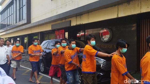 2. Belasan tersangka narkotika terborgol-berjalan dengan pengawalan petugas kepolisian bersenjata menuju Ditresnarkoba Polda Jatim