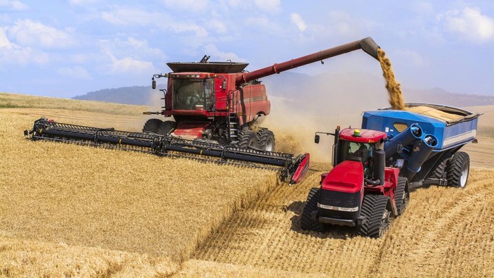 2163463787 A Combine Offloading Grain To A Tractor Pulled Grain Cart In Southeast Washington; Washington, United States Of America. (Photo by: Rick Dalton/Design Pics Editorial/Universal Images Group via Getty Images)