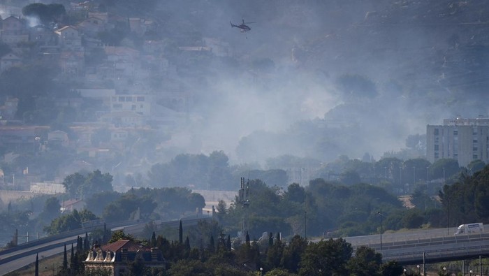Asap Kebakaran Hutan Bikin Prancis Selatan Gelap Smoke rises over Marseille as a fast-moving wildfire spreads on the outskirts the city, southern France, July 8, 2025. REUTERS/Alexandre Dimou