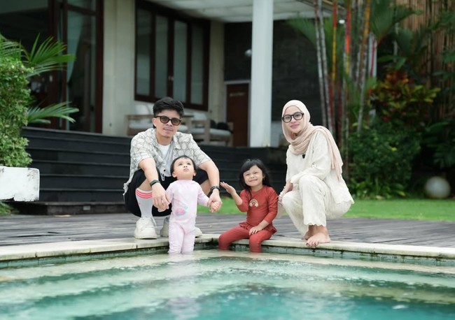 Seperti dalam foto yang satu ini saat Aurel berpose bersama suami dan kedua anaknya di pinggir kolam renang. Sambil berjongkok, terlihat tubuhnya yang kini makin ramping. Foto: Instagram/@aurelie.hermansyah