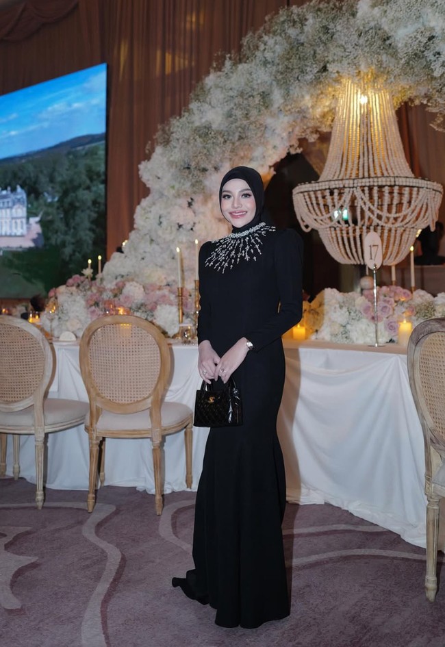 Tampil dengan busana serba hitam, Aurel terlihat cantik memukau. Dress panjang fit body membuat lekuk tubuhnya semakin jelas terlihat. Penampilannya juga makin santun dengan hijab yang menutup kepalanya. Foto: Instagram/@aurelie.hermansyah