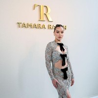 Sentuhan feminin dan sedikit vintage muncul lewat detail pita hitam yang menghiasi garis pinggang, dada, hingga leher gaun. Untuk melengkapi gayanya, Hailee memilih sepatau pump hitam berujung runcing dan clutch hitam sederhana. Dia tampil cukup minimalis dalam pemilihan aksesori, membiarkan gaun menjadi fokus utama penampilannya. Foto: Getty Images/Lyvans Boolaky,Jacopo Raule,Antoine Flament