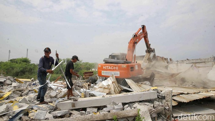 Hambat Saluran Air, 400 Bangli di Babelan Bekasi Dibongkar Alat berat menghancurkan bangunan liar di kawasan Jalan Pulo Timaha, Kecamatan Babelan, Kabupaten Bekasi, Jawa Barat, Rabu (9/7/2025).