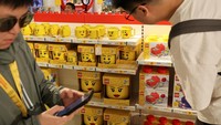 Pengunjung berbelanja di toko suvenir Legoland Shanghai Resort pada hari pembukaannya di Shanghai, China, Sabtu (5/7/2025). Penjualan Lego meningkat tajam sejak pembukaan taman ini. (REUTERS/Go Nakamura)  