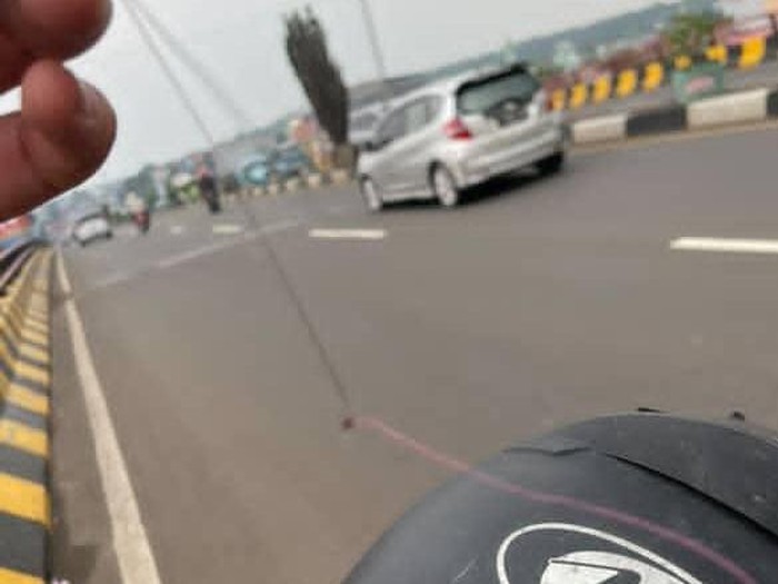 Pemotor terluka di leher karena terjerat benang layangan saat melintas di Jalan Raya Cileungsi, Bogor, Jabar. Korban juga hampir mengalami kecelakaan. (dok Istimewa)