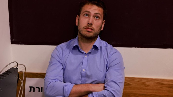 Avner, the son of Israeli Prime Minister Benjamin Netanyahu, sits inside the district courtroom in Tel Aviv before the start of his father's hearing on December 10, 2024. Netanyahu, the first sitting prime minister of Israel to face a criminal trial, is expected to testify for the first time when his corruption case resumes on December 10 on charges of bribery, fraud and breach of public trust in three separate cases.    MENAHEM KAHANA/Pool via REUTERS