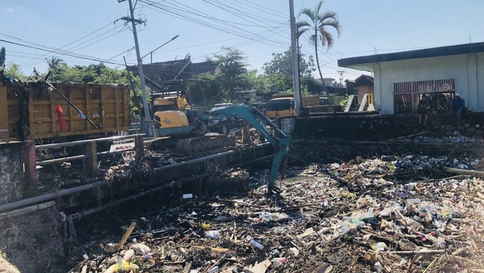 Proses pengerukan sampah yang menumpuk di jembatan Sungai Dodokan, Kelurahan Dasan Geres, Kecamatan Gerung, Lombok Barat. (M Zahiruddin/detikBali)