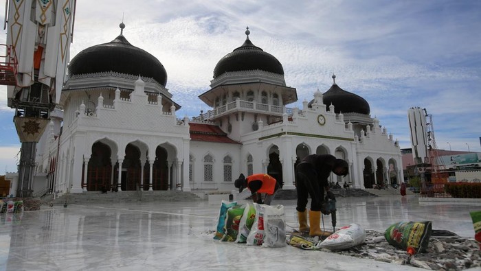Tingkatkan Fasilitas, Masjid Raya Baiturrahman Direnovasi Pekerja membongkar lantai keramik halaman masjid yang rusak saat renovasi Masjid Raya Baiturrahman, Banda Aceh, Aceh, Rabu (9/7/2025). Pemprov Aceh mengalokasikan anggaran tahun 2024 dan 2025 sebesar Rp50 miliar untuk renovasi Masjid Raya Baiturrahman yang meliputi perbaikan membran dan sistem hidrolik payung, lantai marmer, tempat wudu, dan fasilitas lainnya guna kenyamanan jamaah saat beribadah dan wisatawan yang berkunjung. ANTARA FOTO/Ampelsa.