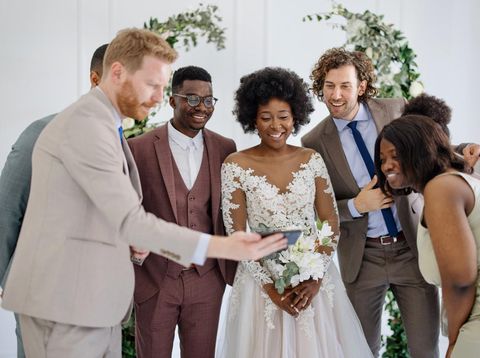 Woman takes a photo of a newly married couple at the end of the ceremony.
