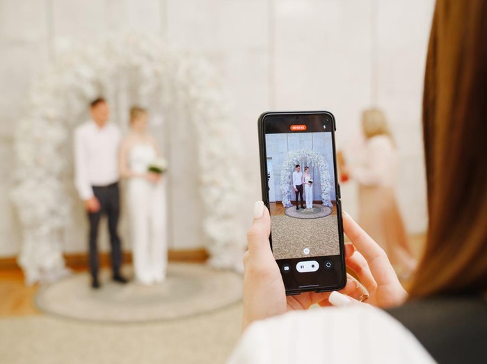 full-length portrait of the newlyweds and their friends at the wedding. The bride and groom with bridesmaids and friends of the groom are having fun and rejoicing at the wedding.