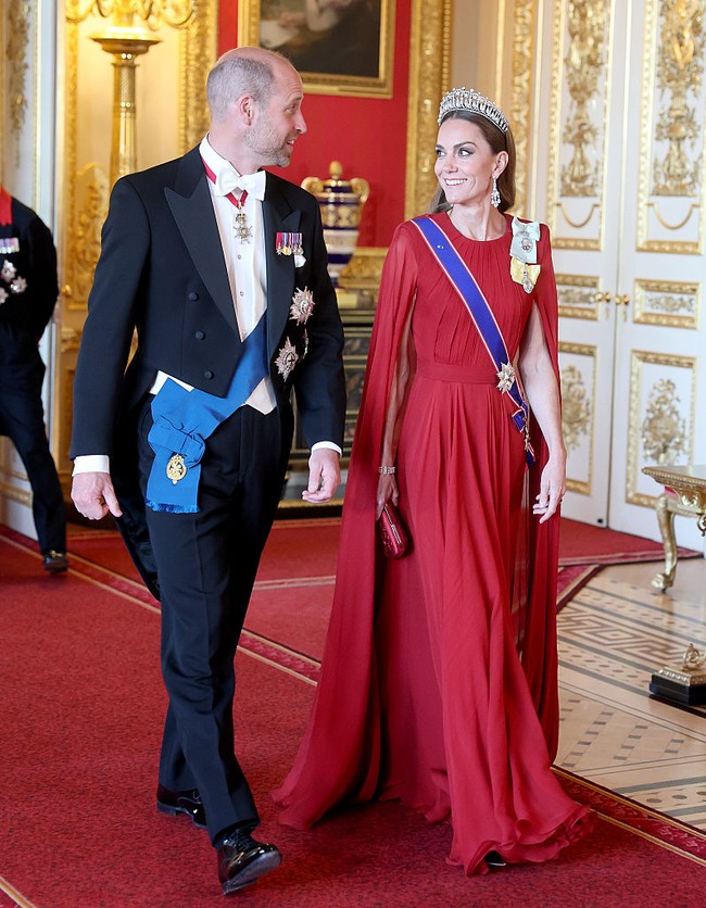 Putri Wales Catherine atau Kate Middleton yang turut hadir menandai momen tersebut dengan penampilan yang sarat keeleganan dan makna. Tubuhnya dibalut gaun merah bergaya cape atau jubah dari rumah mode Prancis Givenchy. Gaun tersebut dirancang oleh direktur kreatifnya, Sarah Burton, yang berasal dari Inggris. Sarah, mantan perancang Alexander McQueen, merupakan salah satu desainer andalan Kate sekaligus sosok yang berada di balik gaun pengantin ikonis ibu tiga anak itu. (Foto: Chris Jackson/Getty Images)