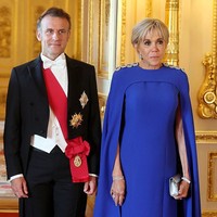 Brigitte Macron yang belum lama ini berkunjung ke Indonesia juga hadir dalam balutan gaun serupa. Busana berbahan silk crepe tersebut disiapkan khusus oleh Louis Vuitton. Pada bagian pundak, diberi aksentuasi berbentuk kancing berlian yang diaplikasikan dengan teknik hand-embroidery.  (Foto: Chris Jackson/Getty Images)
