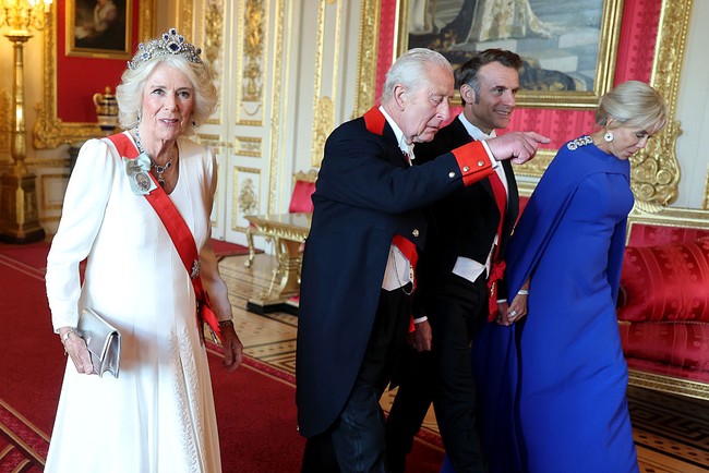 Sementara itu, Ratu Camilla memakai gaun putih lengkap dengan perhiasan nan glamor. Jika disanding berbarengan, warna busana dari ketiga wanita ini merepresentasikan bendera Prancis dan Inggris. (Foto: Chris Jackson/Getty Images)