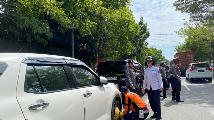 Dishub Makassar bersama aparat kepolisian menggembok mobil yang parkir di badan jalan.
