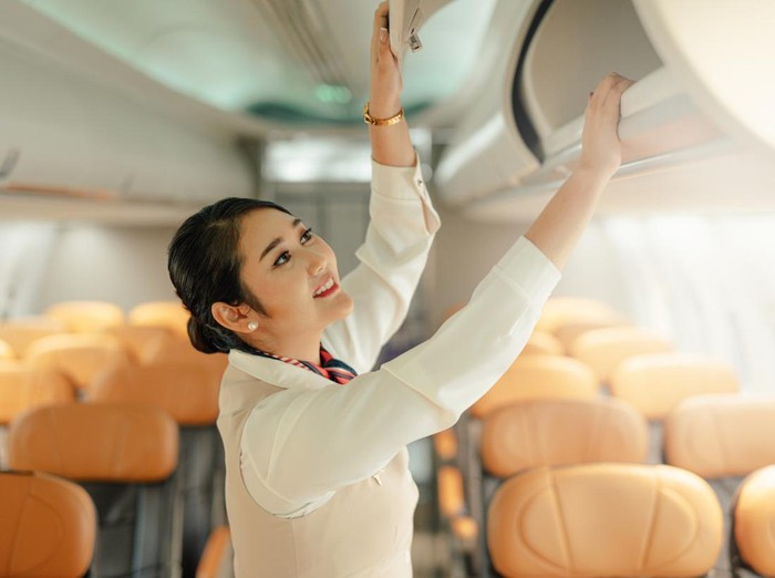 Cabin crew or air hostess working in airplane. Airline transportation and tourism concept.