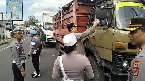 Kapolres Tabanan AKBP I Putu Bayu Pati membagikan makanan dan minuman kepada para supir yang terjebak di jalur Denpasar-Gilimanuk akibat jalan amblas, Kamis (10/7/2025).