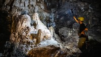 Petugas menunjukkan stalaktit dan stalagmit di dalam situs geologi Gua Petruk, Desa Candirenggo, Kecamatan Ayah, Kebumen, Jawa Tengah, Kamis (10/7/2025). Foto: ANTARA FOTO/Aprillio Akbar