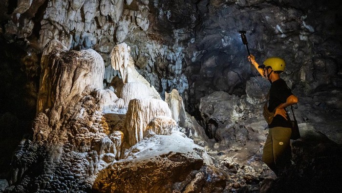 Petugas menunjukkan stalaktit dan stalagmit di dalam situs geologi Gua Petruk, Desa Candirenggo, Kecamatan Ayah, Kebumen, Jawa Tengah, Kamis (10/7/2025). Gua yang merupakan bagian dari Geopark Kebumen itu resmi diakui sebagai UNESCO Global Geopark pada 2025 yang menyuguhkan keajaiban formasi karst dan sungai bawah tanah sebagai warisan geologi purba Indonesia. ANTARA FOTO/Aprillio Akbar/rwa.