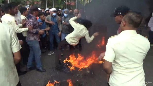 Sekuriti UHO Kendari terjatuh di dekat ban yang dibakar saat demo yang berujung ricuh.