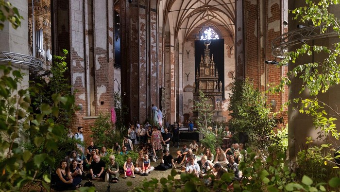 People visit an art installation that transformed a 14th century church of St. John into an urban forest, in Gdansk, Poland, July 2, 2025. REUTERS/Lukasz Glowala