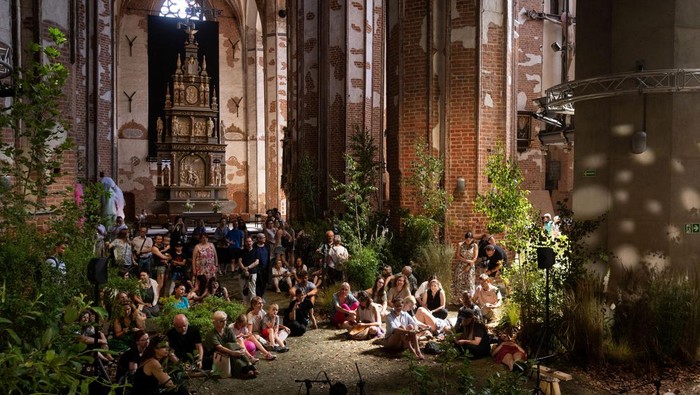 People visit an art installation that transformed a 14th century church of St. John into an urban forest, in Gdansk, Poland, July 2, 2025. REUTERS/Lukasz Glowala