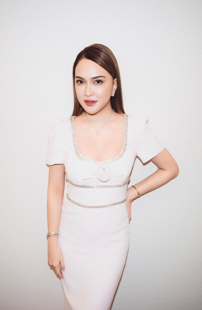 Shandy Aulia sendiri tampil cantik dan feminin dalam balutan dress panjang berwarna baby pink. Gaun tersebut memiliki potongan leher square yang cukup rendah. Detail bordir kilau perak tampak menghiasi garis leher, pinggang, dan bagian bawah dada. Di bagian dadanya juga terdapat hiasan berbentuk pita dan bunga mawar. Foto: Instagram/@shandyaulia