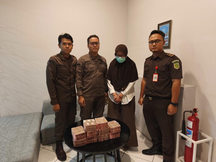 Kejari Karanganyar menunjukkan tersangka korupsi pengadaan alat kesehatan Dinas Kesehatan Karanganyar, Purwanti, dan uang sitaan Rp 1 miliar, Kamis (10/7/2025).