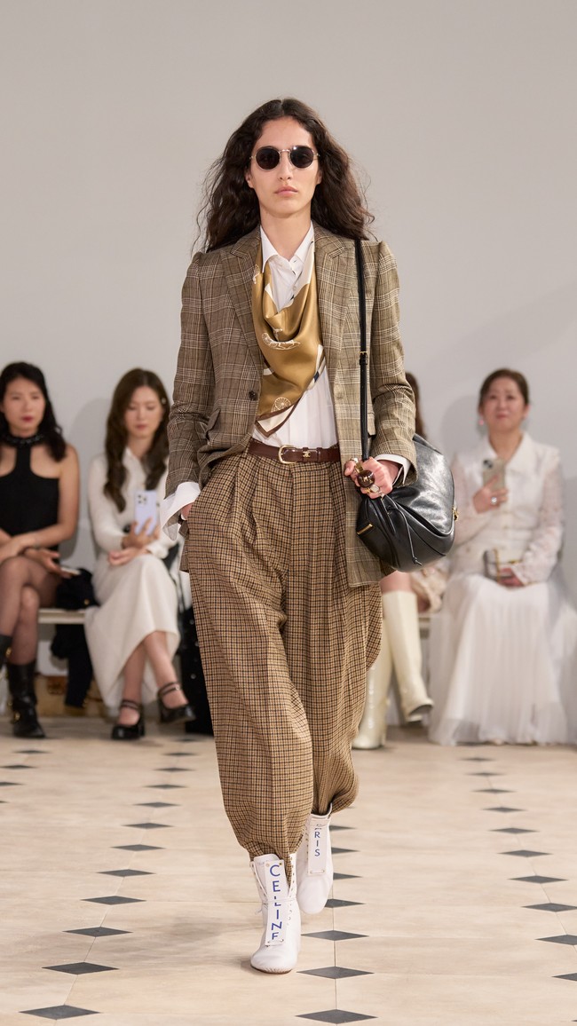 Pengaruh Philo lantas terasa lewat estetika minimalis yang slouchy dalam potongan blazer hingga bawahan oversized seperti harem pants atau high-waist denim. Sementara itu, celana slim yang menempel ketat di celana hingga dekonstruksi atasan tailored seperti crop tuxedo jacket sebagai luaran gaun mewakili Celine era Slimane. (Foto: Dok. Celine)