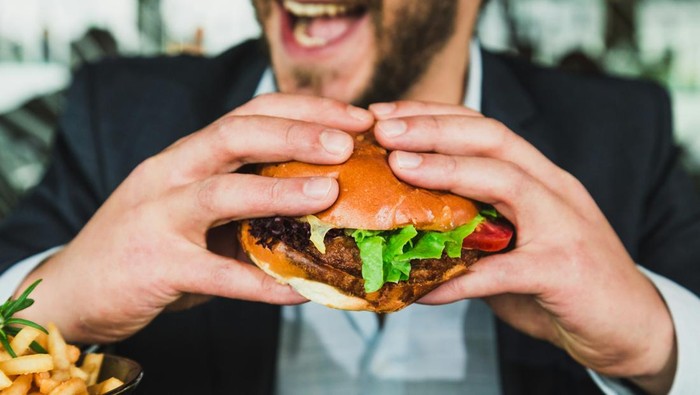 Pria sedang makan burger, makanan cepat saji