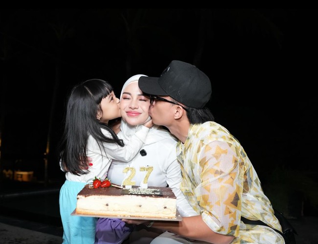 Sebelum menggelar pesta, Aurel sudah lebih dulu mendapat kejutan ulang tahun dari suami dan putrinya. Sambil membawa kue ulang tahun, suami dan putrinya itu terlihat mencium pipi Aurel. Foto: Instagram/@aurelie.hermansyah