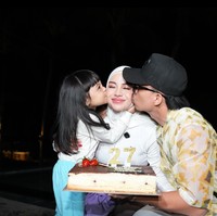 Sebelum menggelar pesta, Aurel sudah lebih dulu mendapat kejutan ulang tahun dari suami dan putrinya. Sambil membawa kue ulang tahun, suami dan putrinya itu terlihat mencium pipi Aurel. Foto: Instagram/@aurelie.hermansyah