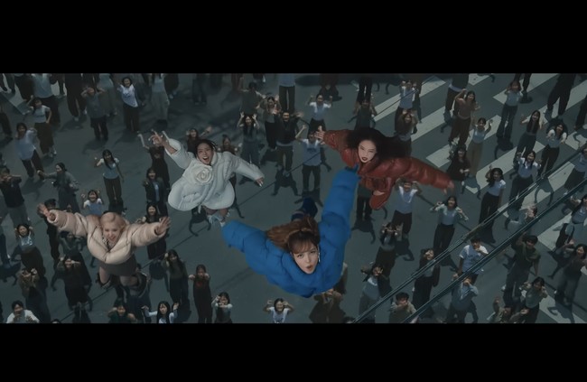 Kini penggemar ramai menyorot adegan personel BLACKPINK terbang di video klip JUMP bak adegan film superhero. Jennie, Lisa, dan Rose memakai koleksi puffer jacket rancangan desainer Dingyun Zhang, masing-masing berwarna merah, biru, dan hijau. Sedangkan Jisoo memakai puffer jacket putih Juntae Kim beraksen bunga mawar. Foto: dok. YG Entertainment