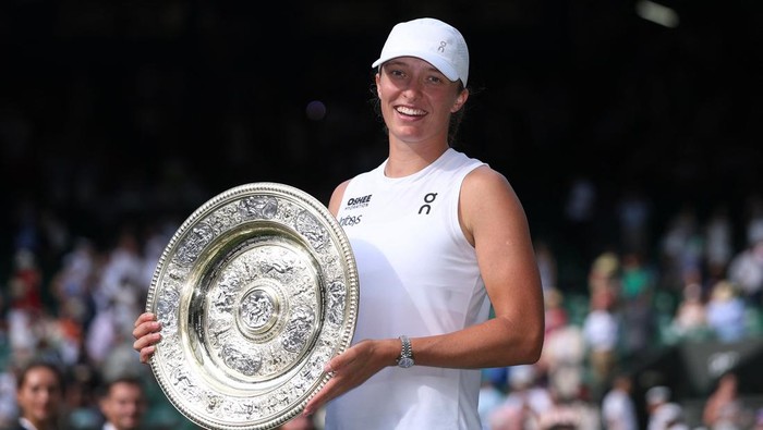 Tennis - Wimbledon - c, Britain - July 12, 2025 Polands Iga Swiatek celebrates with the trophy after winning the womens singles final at Wimbledon against Amanda Anisimova of the U.S. REUTERS/Toby Melville