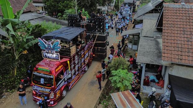 Warga menyaksikan gelaran Urek Urek Carnival yang diiringi perangkat audio berkapasitas besar di Desa Urek-urek Kecamatan Gondanglegi, Kabupaten Malang, Jawa Timur, Sabtu (12/7/2025). Karnaval dengan iringan-iringan audio kapasitas besar tersebut diselenggarakan tiap tahun saat momentum selamatan desa atau setelahnya dalam rangka memeriahkan bersih desa yang diperingati pada bulan Suro pada penanggalan Jawa. ANTARA FOTO/Irfan Sumanjaya/nym.