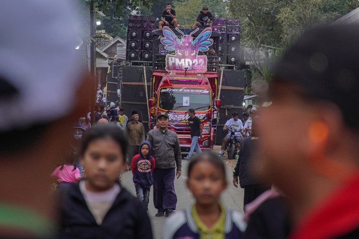Warga menyaksikan gelaran Urek Urek Carnival yang diiringi perangkat audio berkapasitas besar di Desa Urek-urek Kecamatan Gondanglegi, Kabupaten Malang, Jawa Timur, Sabtu (12/7/2025). Karnaval dengan iringan-iringan audio kapasitas besar tersebut diselenggarakan tiap tahun saat momentum selamatan desa atau setelahnya dalam rangka memeriahkan bersih desa yang diperingati pada bulan Suro pada penanggalan Jawa. ANTARA FOTO/Irfan Sumanjaya/nym.