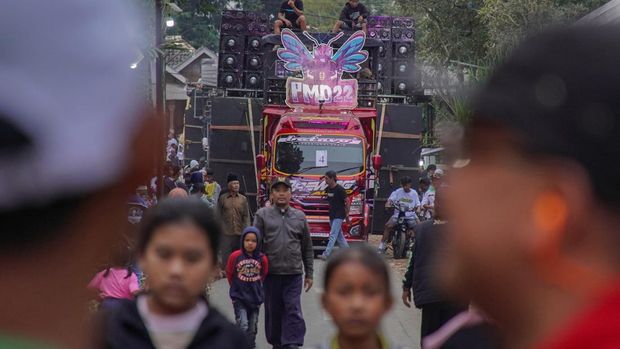 Warga menyaksikan gelaran Urek Urek Carnival yang diiringi perangkat audio berkapasitas besar di Desa Urek-urek Kecamatan Gondanglegi, Kabupaten Malang, Jawa Timur, Sabtu (12/7/2025). Karnaval dengan iringan-iringan audio kapasitas besar tersebut diselenggarakan tiap tahun saat momentum selamatan desa atau setelahnya dalam rangka memeriahkan bersih desa yang diperingati pada bulan Suro pada penanggalan Jawa. ANTARA FOTO/Irfan Sumanjaya/nym.