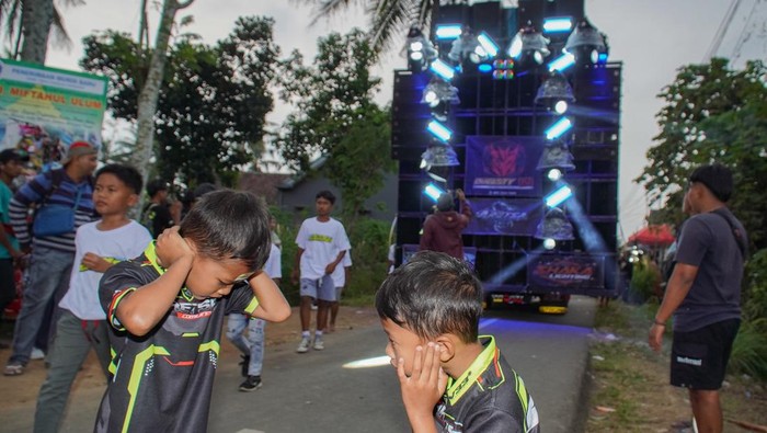 Warga menyaksikan gelaran Urek Urek Carnival yang diiringi perangkat audio berkapasitas besar di Desa Urek-urek Kecamatan Gondanglegi, Kabupaten Malang, Jawa Timur, Sabtu (12/7/2025). Karnaval dengan iringan-iringan audio kapasitas besar tersebut diselenggarakan tiap tahun saat momentum selamatan desa atau setelahnya dalam rangka memeriahkan bersih desa yang diperingati pada bulan Suro pada penanggalan Jawa. ANTARA FOTO/Irfan Sumanjaya/nym.