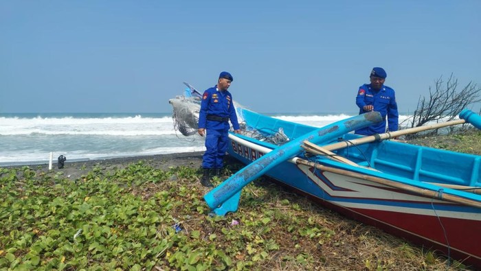 Kapal nelayan dievakuasi setelah terbalik karena terhantam ombak di Pantai Samas, Bantul, Minggu (13/7/2025).
