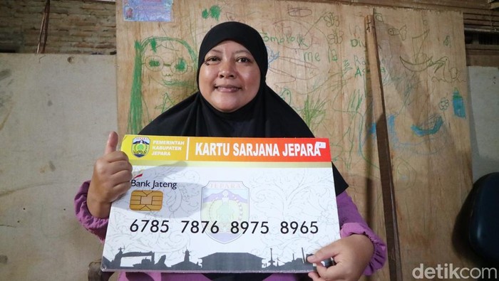 Orang tua Indurasmi Kirna Firdaus, Mei Wulandari saat menunjukan kartu sarjana Jepara dirumahnya Desa Bulungan Kecamatan Pakis Aji, Minggu (13/7/2025).