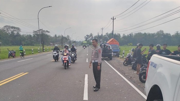 Polisi mengecek lokasi kecelakaan akibat benang layangan di Jalan Wates-Jogja, ruas Pengasih, Kulon Progo, Minggu (13/7/2025).