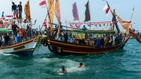 Sejumlah nelayan berenang merebut sesajen yang dilarungkan di perairan Selat Sunda. Ruwat Laut dilaksanakan setiap bulan Muharram dalam kalender Islam. Foto: ANTARA FOTO/Muhammad Bagus Khoirunas