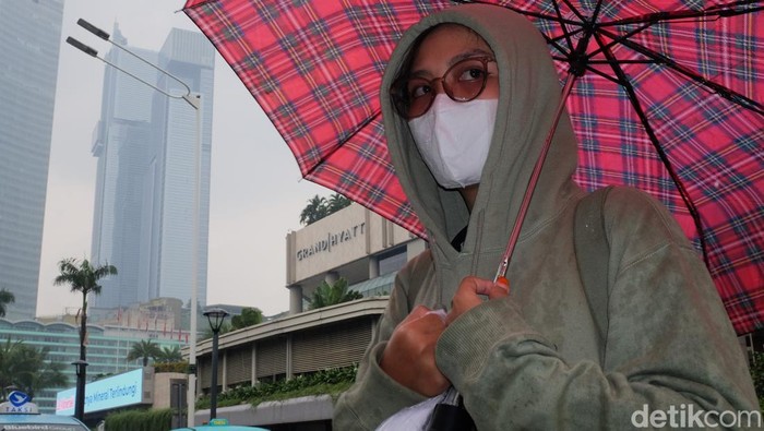 Warga menggunakan payung menerobos gerimis di pelican crossing Jl Thamrin, Jakarta, Senin (14/7/2025). Curah hujan terpantau masih tinggi meskipun sudah memasuki musim kemarau. Berdasarkan prediksi curah hujan bulanan Badan Meteorologi, Klimatologi, dan Geofisika (BMKG), anomali curah hujan di atas normal berlangsung sejak Mei hingga Oktober 2025.  BMKG memprediksi bahwa kemarau 2025 akan mengalami keterlambatan di sekitar 29 persen Zona Musim (ZOM), terutama di wilayah Lampung, sebagian besar Pulau Jawa, Bali, Nusa Tenggara Barat (NTB), dan Nusa Tenggara Timur (NTT).