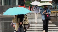 Warga menggunakan payung menerobos gerimis di kawasan Jl Thamrin. Anomali curah hujan yang terjadi saat ini berpotensi memicu musim kemarau basah di sejumlah wilayah Indonesia. Artinya, meskipun telah memasuki musim kemarau secara kalender, curah hujan tetap terjadi dengan intensitas lebih tinggi dari normalnya.