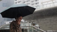 Warga menggunakan payung menerobos gerimis di dekat Halte Bundaran HI. Berdasarkan prediksi curah hujan bulanan Badan Meteorologi, Klimatologi, dan Geofisika (BMKG), anomali curah hujan di atas normal berlangsung sejak Mei hingga Oktober 2025.