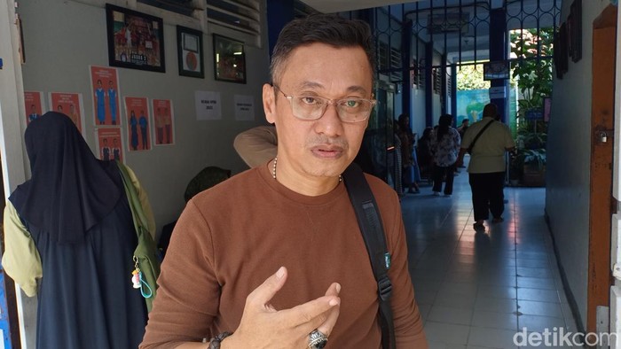 Faisal, seorang karyawan hotel di Makassar saat menunggu anaknya, Muh Raka Aditya selesai mengikuti MPLS 2025 di SMPN 2 Makassar.