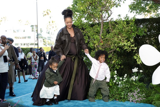 Menghadiri pemutaran perdana film Smurfs bersama kedua buah hatinya, Rihanna tampil elegan di karpet biru dalam balutan koleksi Saint Laurent yang terdiri dari gaun bergaya lingerie yang dilengkapi rok dramatis satin cokelat tua. Jaket kulit oversized menemani sebagai luaran. Penampilannya menegaskan citra fashion icon yang tetap menawan meski sedang hamil anak ketiga. (Foto: REUTERS/Mario Anzuoni)